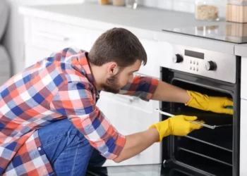 A man in the cleaning of the oven