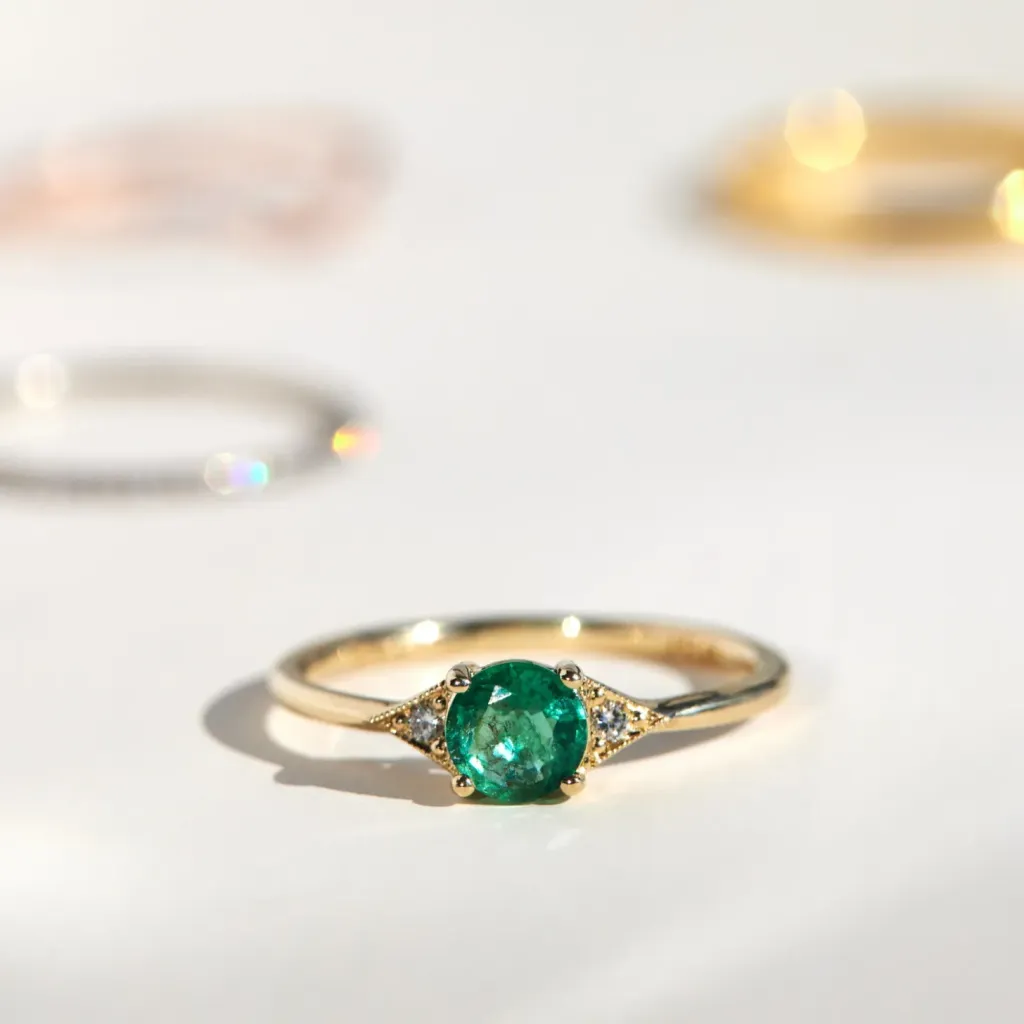 best-diamond-and-emerald-engagement-rings-with-milgrain-triangle-design-and-round-cut-stones