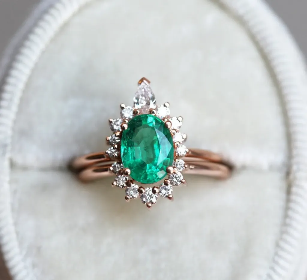 blush-gold-best-emerald-engagement-rings-with-sunburst-style-diamond-halo-design